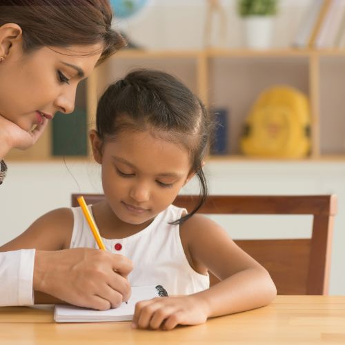 teacher helping a girl with homework