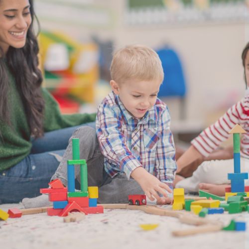 Teacher playing block with toddler